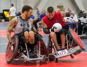 Wheelchair bound veterans participate in a game of quad rugby on the indoor basketball court
